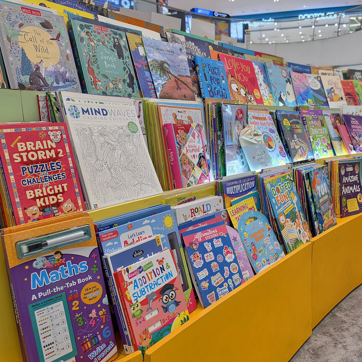 Curved display of children's activity, puzzle and story books at Brain Chapters
